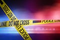 Yellow law enforcement tape isolating crime scene. Blurred background with red and blue police car lights Royalty Free Stock Photo