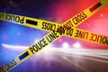 Yellow law enforcement tape isolating crime scene. Blurred view of city street, toned in red and blue police car lights Royalty Free Stock Photo