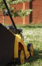 Yellow lawn mower on green grass