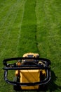 Yellow lawn mower on the green grass