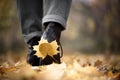 Yellow leaf stuck to the women`s shoe during a walk through the autumn forest. Royalty Free Stock Photo