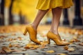 Yellow leather shoes on a woman walking. Set against a charming European city street, with autumn leaves. Perfect