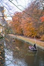 Yellow leaves with blurred image of punting, famous sightseeing boat, along river Cam in Cambridge Royalty Free Stock Photo