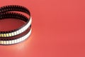 Yellow Led strip coil packaging closeup isolated on red background. Spare part for repair lamp or latern. Diode tape in the Royalty Free Stock Photo