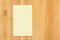 Yellow legal notepad paper with lines on pine wood desk Royalty Free Stock Photo