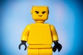 yellow lego figure with an evil face on a blue background