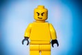 yellow lego figure with an evil face on a blue background