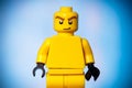 yellow lego figure with a sarcastic face on a blue background