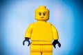 yellow lego figure with a sarcastic face on a blue background