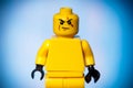 yellow lego figure with a sarcastic face on a blue background