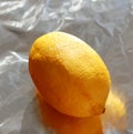 Yellow lemon on bright tinfoil background surface Royalty Free Stock Photo