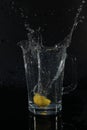 Yellow lemon getting dropped into water fast shutter speed