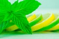 Yellow lemon and lime with fresh green mint on mint colour background Royalty Free Stock Photo