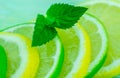 Yellow lemon and lime with fresh green mint on mint colour background Royalty Free Stock Photo