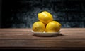 Yellow lemon in a plate on a wooden table and dark background