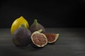 Whole lemon, figs and one sliced on wooden table Royalty Free Stock Photo