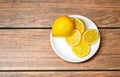 Yellow lemon with lemon slices on a white ceramic plate top view Royalty Free Stock Photo