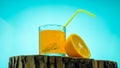 Yellow lemonade in a transparent glass on a blue background. Orange juice Royalty Free Stock Photo
