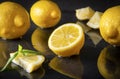 Yellow lemons with Basil on a black , half, slices and whole citrus