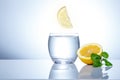 Yellow lemons in a glass of water. Tasty and healthy food. Seasonal drinks