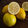 Yellow lemons on wooden table with 1 halved lemon Royalty Free Stock Photo