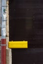 yellow letterbox on dark wooden door