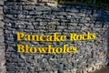 Yellow letters on a wall rock in the enter of pancake rocks in Punakaiki, South island, in New Zealand