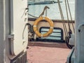 A yellow lifebelt, lifebuoy, water wheely also known as Kisbee ring on a an old boat Royalty Free Stock Photo