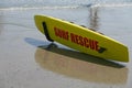 Yellow lifeguard surf rescue surf board by the ocean on the sand