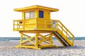 A yellow lifeguard tower on a sandy beach next to the ocean Royalty Free Stock Photo