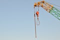 Yellow lifting telescopic arms with hook mobile crane on a background of blue sky. Royalty Free Stock Photo