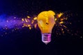 Yellow light bulb exploding black background Royalty Free Stock Photo