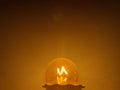 Yellow light bulb lit in the dark close up view Royalty Free Stock Photo