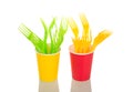 Yellow and light green forks are in colorful plastic cups isolated on white Royalty Free Stock Photo