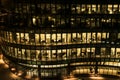 Yellow light windows of an office building at night in Boston late night at work. glass curtain wall office building Royalty Free Stock Photo