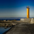 Yellow lighthouse on breakwater dam Royalty Free Stock Photo