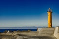 Yellow lighthouse on breakwater dam Royalty Free Stock Photo