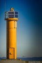 Yellow lighthouse on breakwater dam Royalty Free Stock Photo