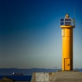 Yellow lighthouse on breakwater dam Royalty Free Stock Photo