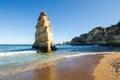 Yellow limestone stack on the shoreline in Dona Ana Beach. Lagos, District Faro, Algarve, Southern Portugal