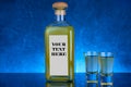 YELLOW LIQUOR BOTTLE AND SHOTS, WITH BLUE BACKGROUND AND LABEL WITH COPYSPACE