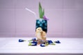 A yellow little chick with butterfly pea water and ice in a champagne glass is decorated by orchid and pandan leaf. It`s shown an Royalty Free Stock Photo