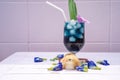 A yellow little chick with butterfly pea water and ice in a champagne glass is decorated by orchid and pandan leaf. It`s shown an Royalty Free Stock Photo