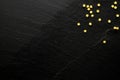 Small golden sugar stars on black background with space for your message