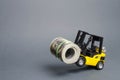 A yellow loader stands on the rear wheels holding a big bundle of dollars. concept of attracting investment, issuing concessional
