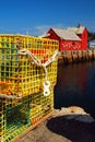 Yellow lobster traps stand on the waterÃ¢â¬â¢s edge near a red fishing shack