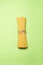 Yellow long spaghetti on a green paper background