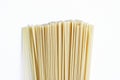 Yellow long spaghetti on a light background. Thin pasta arranged in rows. Italian raw pasta.