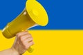 Yellow loudspeaker on background of flag of Ukraine.Concept Yellow press, fakes and not true
