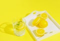 Yellow macaroon with lemons on a tray and glass of lemonade on sulit background . Summer refreshment concept Royalty Free Stock Photo